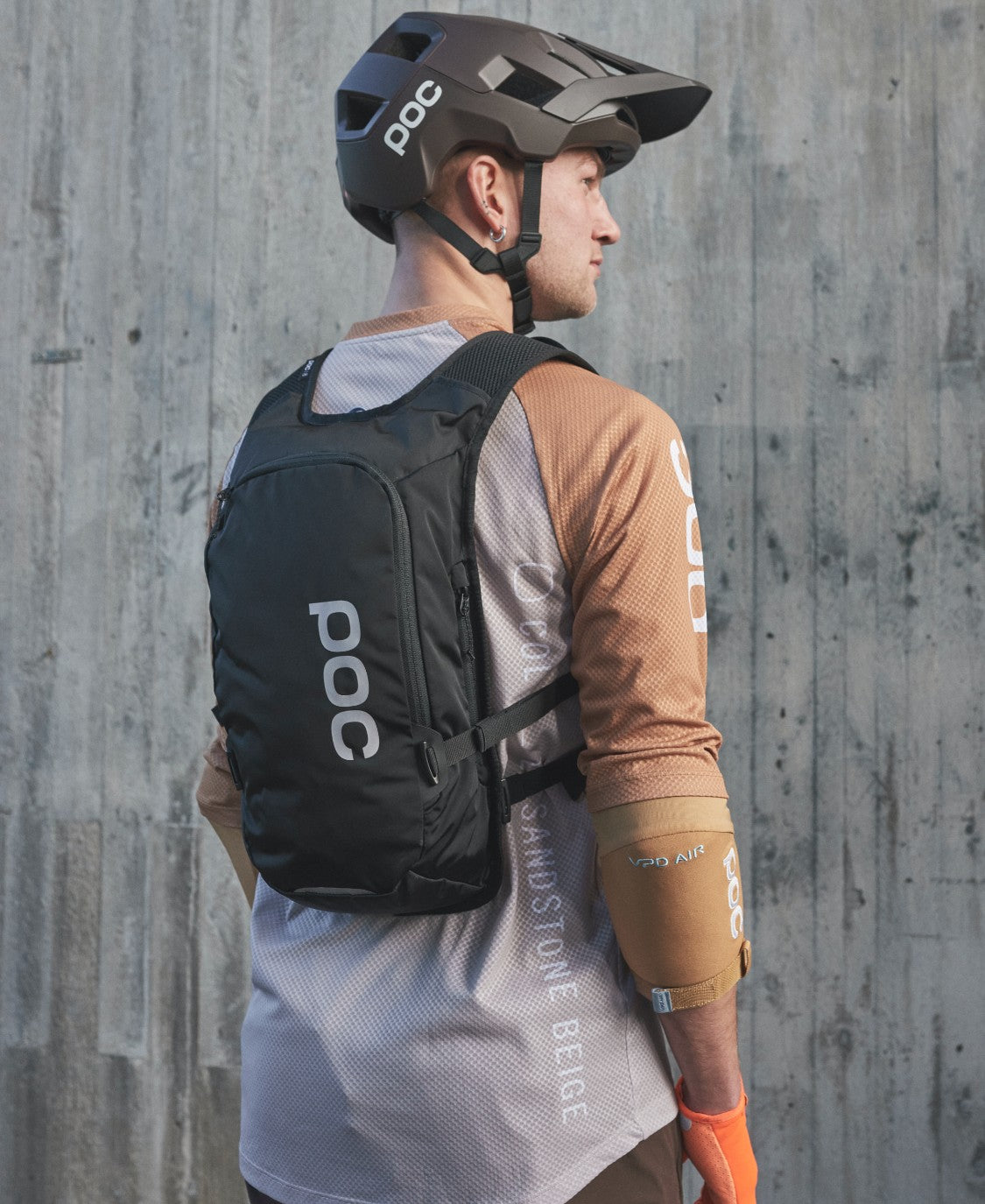 Column VPD Rucksack 13L Ein Mann mit Fahrradhelm trägt einen schwarzen Column VPD Backpack 13L.