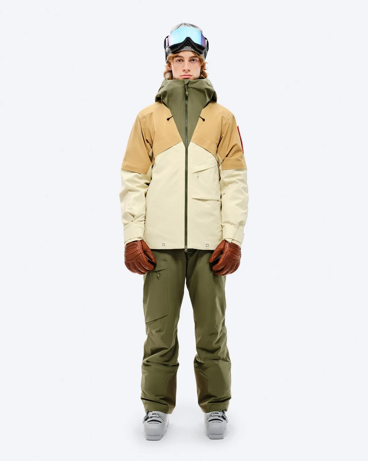 Person in winter gear: GORE-TEX jacket in beige/brown, Winter Moss trousers, gloves and ski goggles.