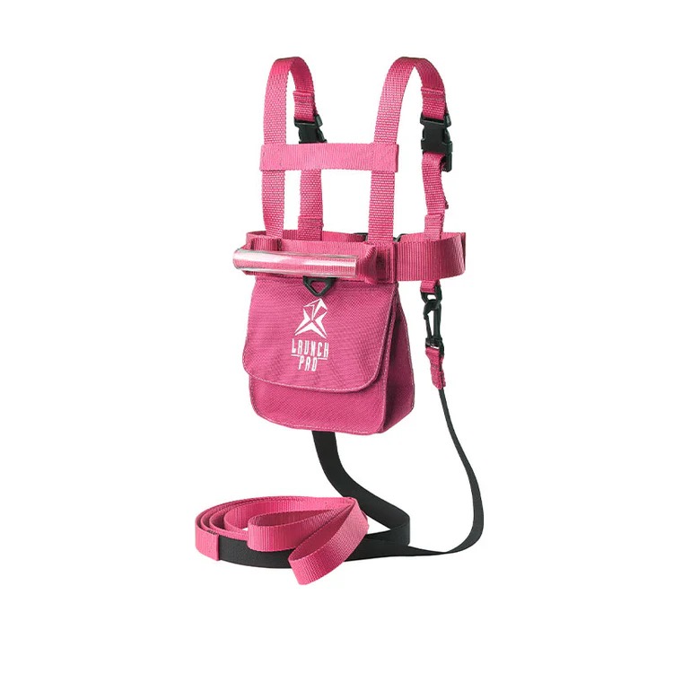 Pinkes Skigeschirr für Kleinkinder mit Haltegriff und abnehmbarer Leine. Verstellbare Schulter- und Taillengurte, Fronttasche mit 'LAUNCH PRO'-Logo und schwarze Schnallen. Leine aufgerollt für mehr Sicherheit.