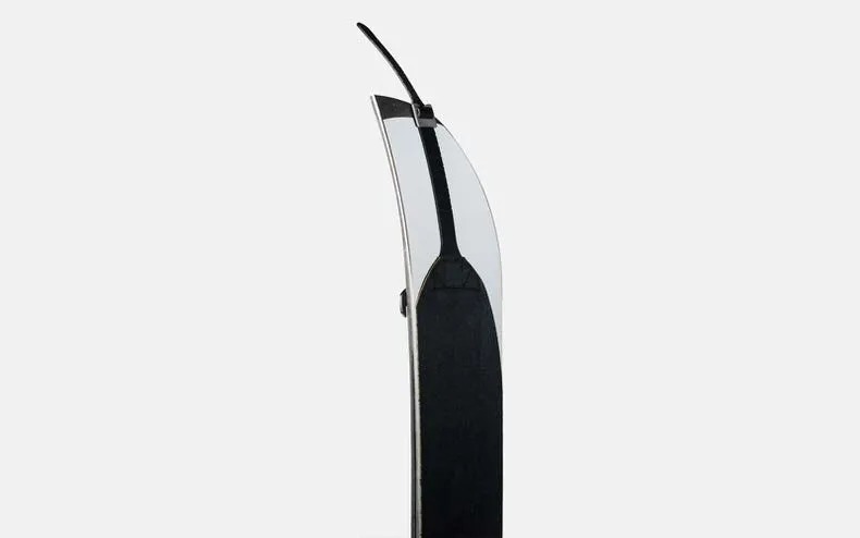 Side view of a Jones Nomad Pro splitboard skin, black and white, with tensioning system, against a light background.