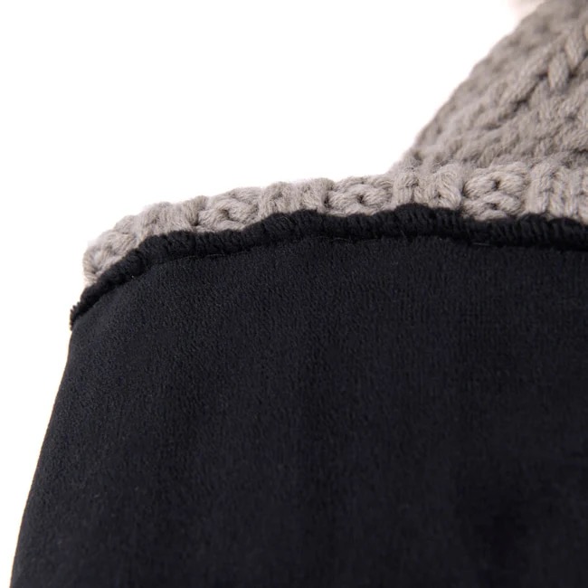 Détail d'un tissu noir avec une bordure grise crochetée en haut, formant un bord décoratif.