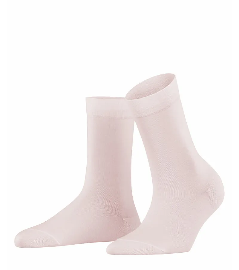 Due calze da donna rosa chiaro in piedi su uno sfondo bianco.