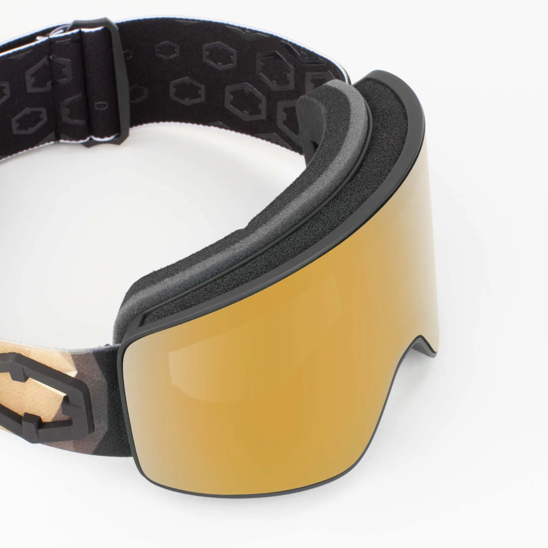 Nahaufnahme der Out Of Void Origami Gold24 MCI Skibrille mit goldener, zylindrischer Linse. Schwarzer Rahmen und gemustertes Kopfband.