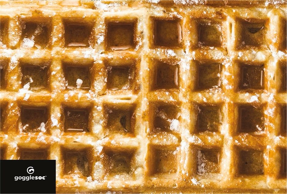 Detailaufnahme einer Waffel mit Puderzucker. Waffel-Design für ein Brillenputztuch.