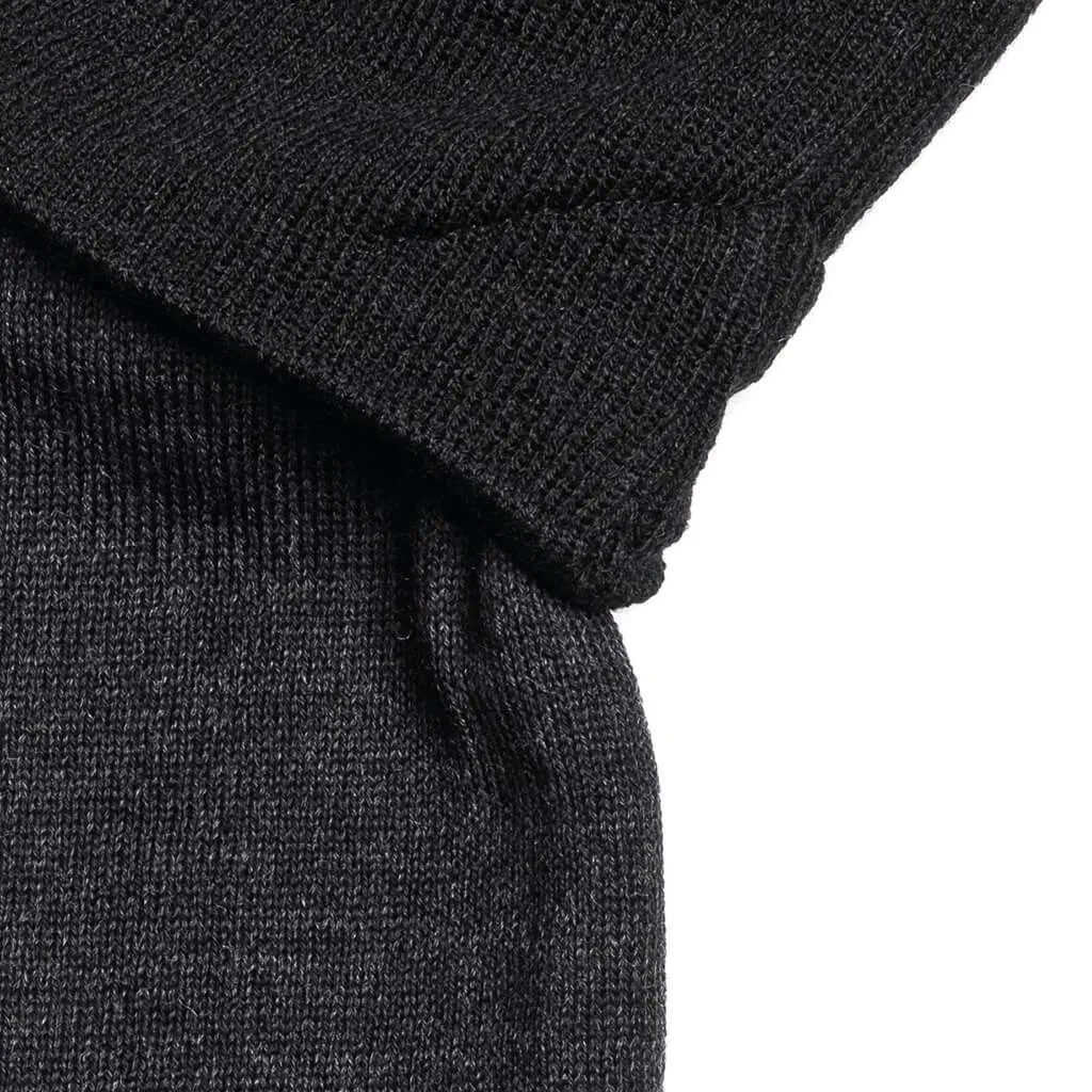 Vue détaillée de l'ensemble bonnet et cache-nez noir "The JB". Motif de tricot reconnaissable.