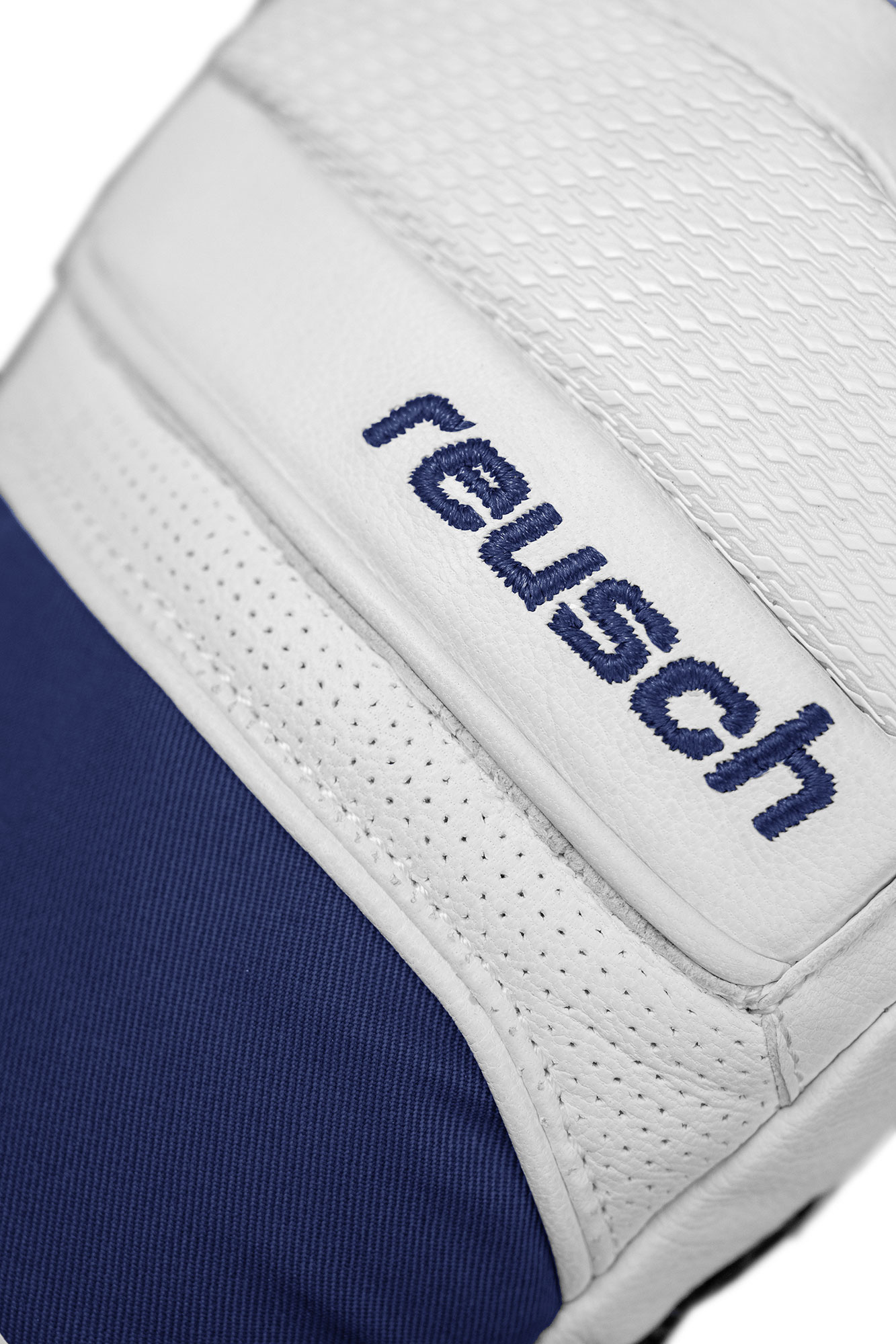 Détail d'un gant de gardien de but blanc avec le texte "reusch" en bleu et une partie en tissu bleu.