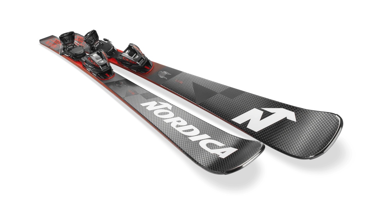 Une paire de skis noirs avec fixations sur un fond blanc. Sur le ski avant, on peut lire en blanc l'inscription "NORDICA".