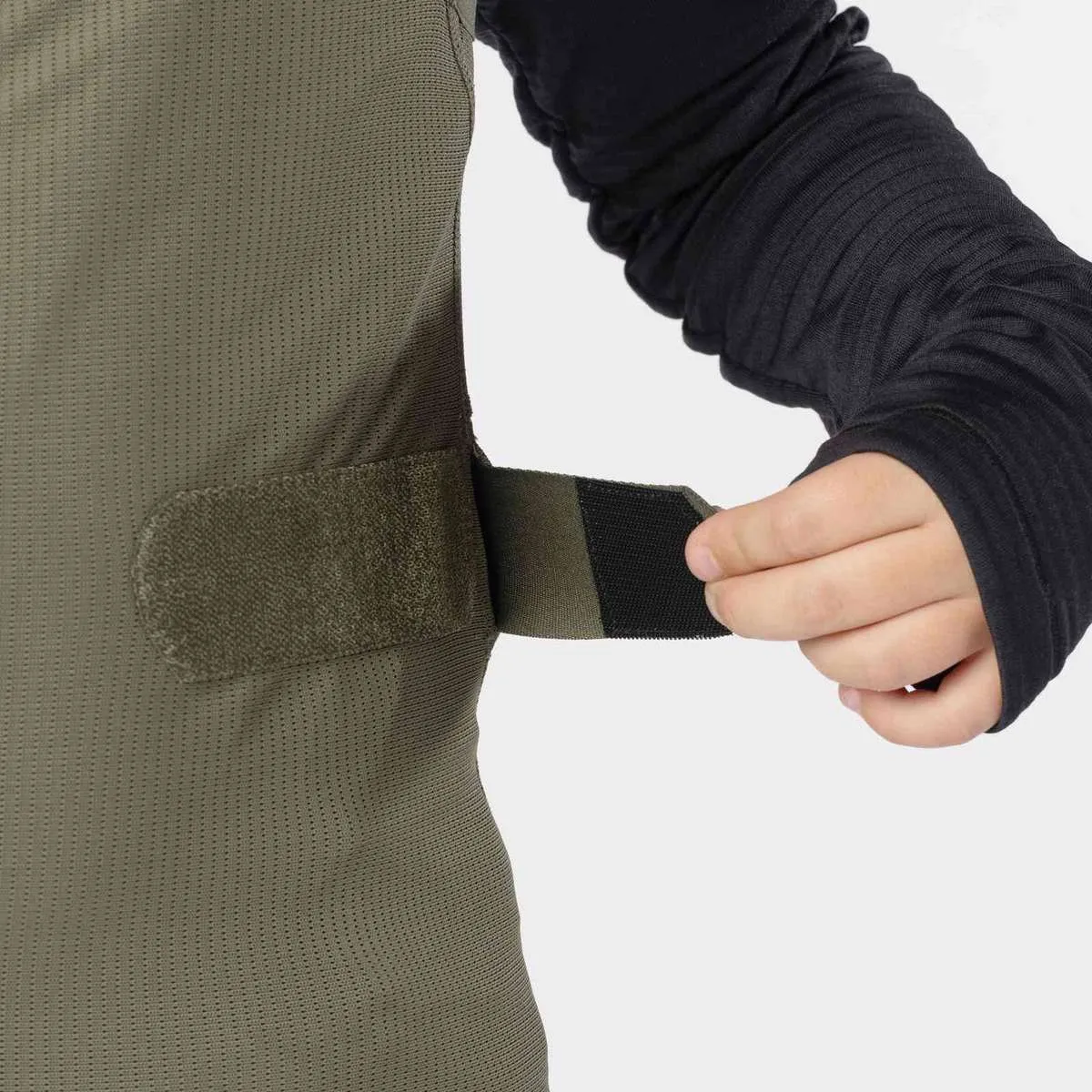 Green junior vest with Velcro fastening at the waistband, worn over a black long-sleeved top.