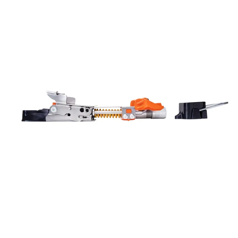 Pièce technique argentée avec rail denté et levier orange, probablement un élément d’une fixation de ski ou d’un mécanisme de réglage. Sur fond blanc immaculé, à côté se trouve un petit accessoire noir muni d’une tige métallique.