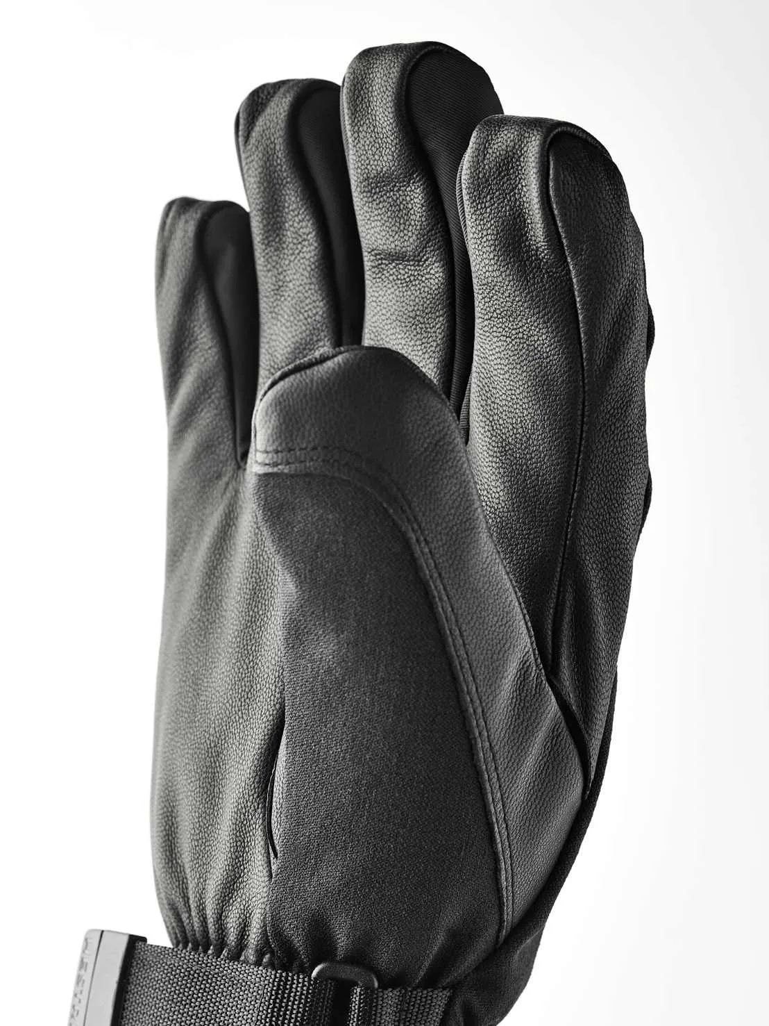 Eine schwarze Lederhandschuh mit fünf Fingern, mit einem Handgelenkband und Schnalle.