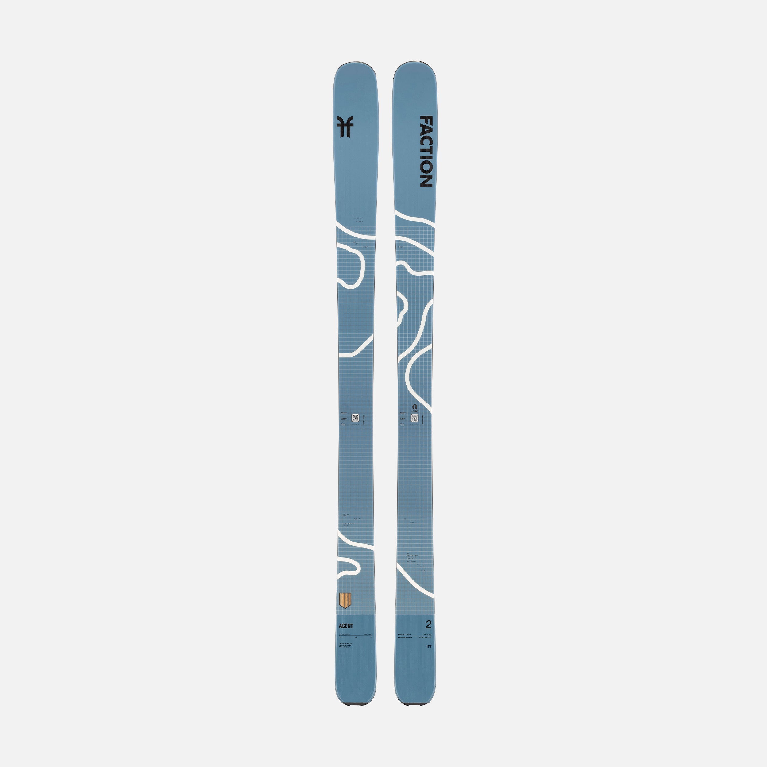 Zwei blaue Ski mit weißen, geschwungenen Linien und einem feinen, hellen Rastermuster, nebeneinander auf einem hellgrauen Hintergrund.