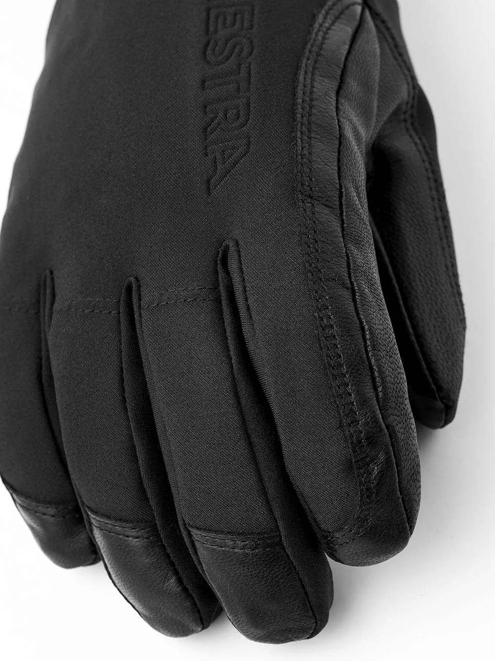 Détail d'un gant HESTRA noir combinant cuir et textile, avec un accent sur la texture et la finition.