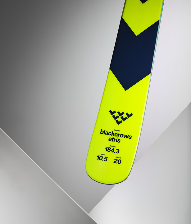 Ski jaune Black Crows Atris Ski jaune Black Crows Atris avec détails techniques sur fond gris.