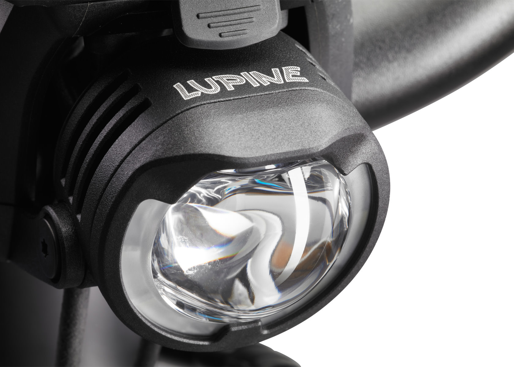 Nahaufnahme der Lupine SL B E-Bike Beleuchtung für Bosch, montiert an einem Fahrradlenker. Der Lampenkopf ist schwarz mit silbernem Lupine Logo.