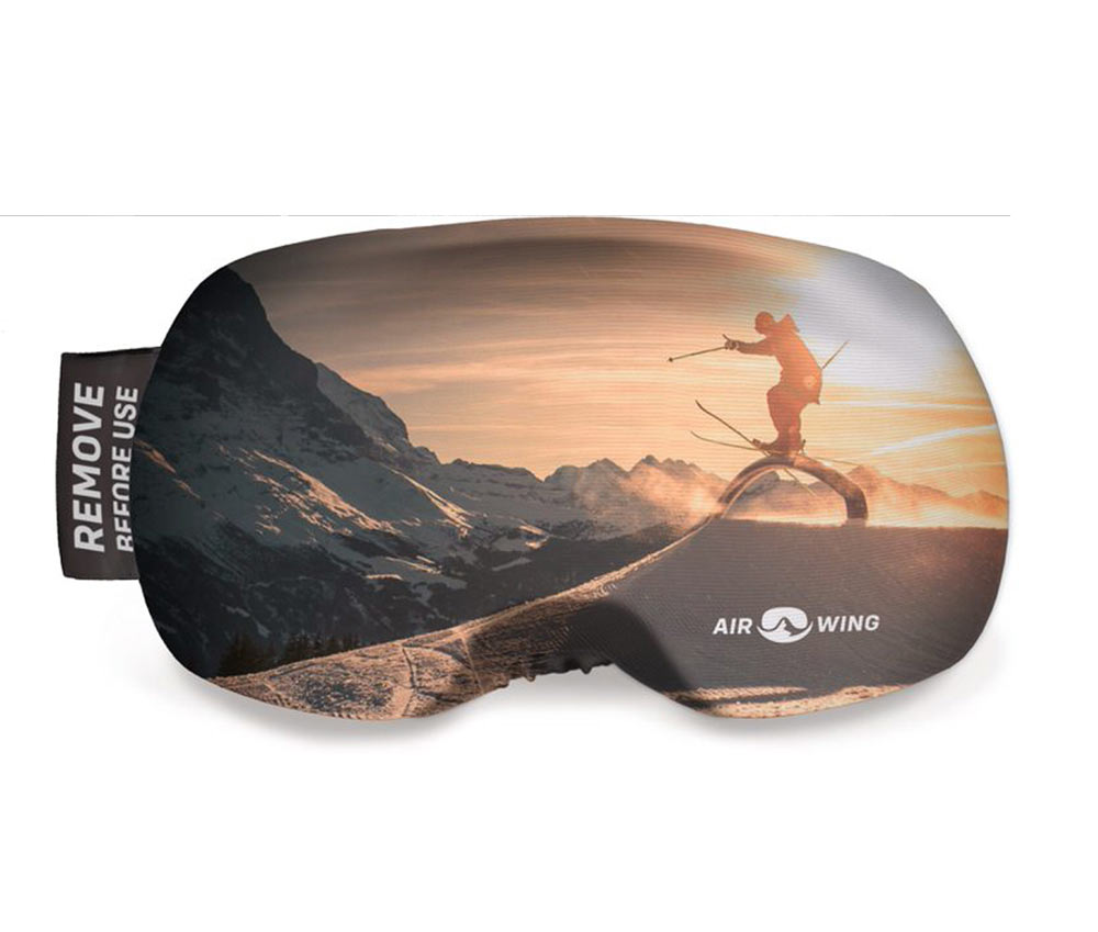Airwing Slope Schutzhülle: Aufdruck mit Berglandschaft und Skifahrer bei Sonnenuntergang. "Remove before use"-Etikett.
