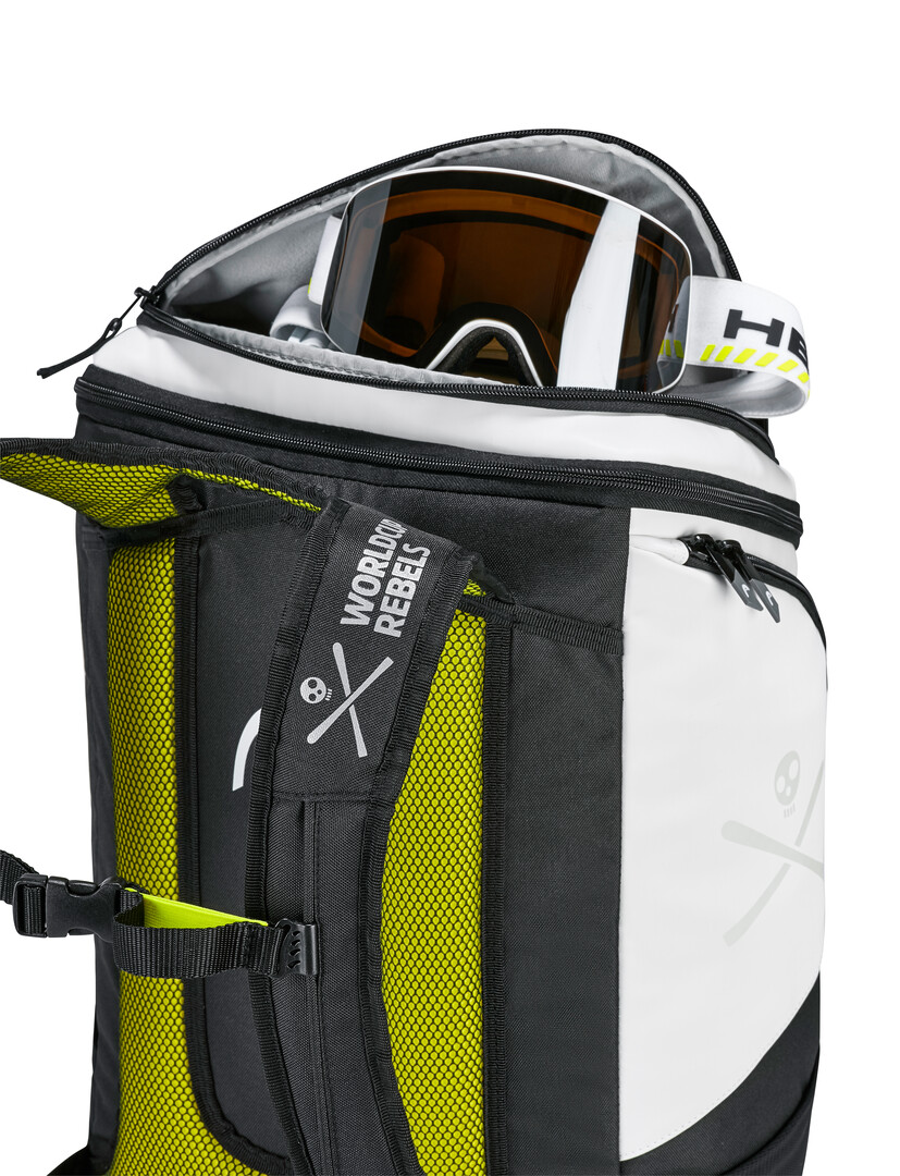 Vue détaillée du sac à dos Head Rebels avec masque de ski dans le compartiment principal ouvert. Coloris noir et blanc avec des accents jaunes.