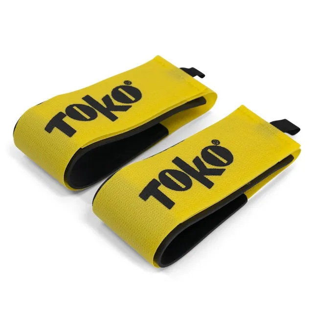 Two yellow "Toko" ski clips with black lettering and black lining are shown on a white background.
