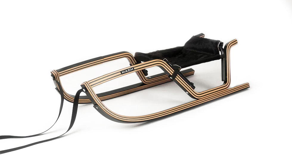 Luge 'FUR HAWK' de MACH, bois avec siège en fourrure, corde de traction, vue latérale. Design noble avec teck foncé et hêtre clair.