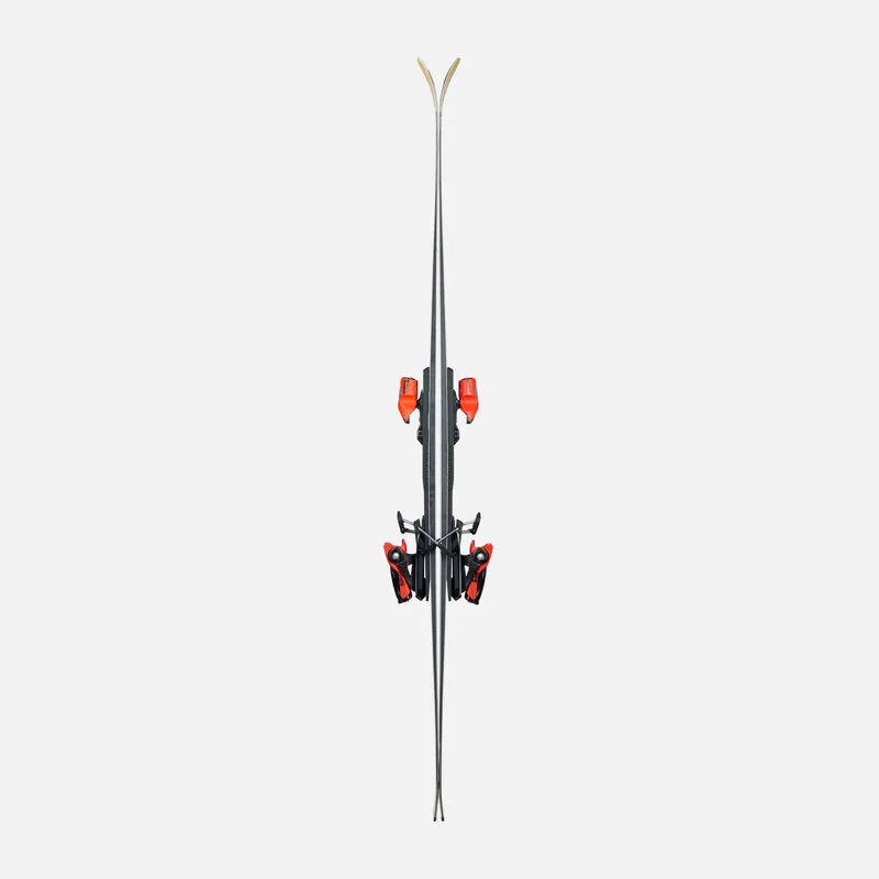 A pair of skis with orange bindings, photographed from above, against a light gray background. The skis are slim and tapered.