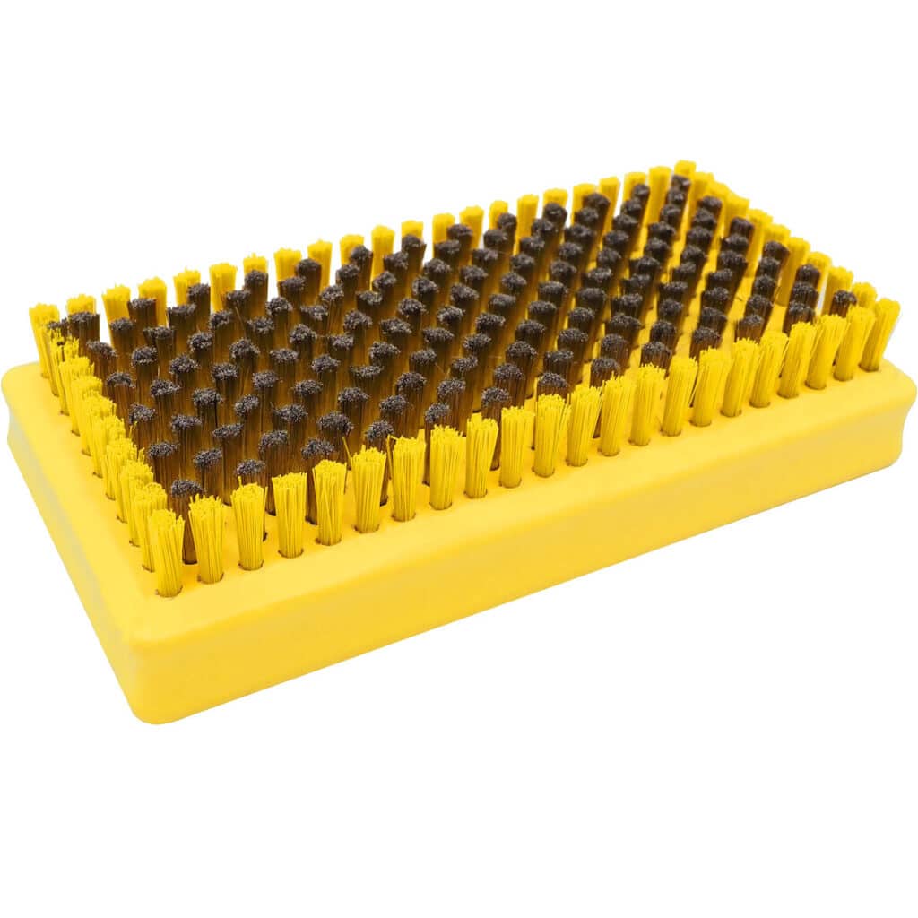 Gelbe Stahlbürste mit Borsten, die in der Mitte braun und am Rand gelb sind, zur Belagpflege.