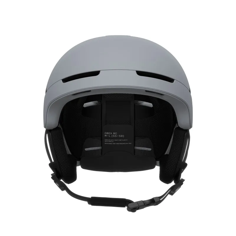 Gray ski helmet from the front, with ventilation openings, earmuffs and adjustable chin strap. Mesh padding on the inside.