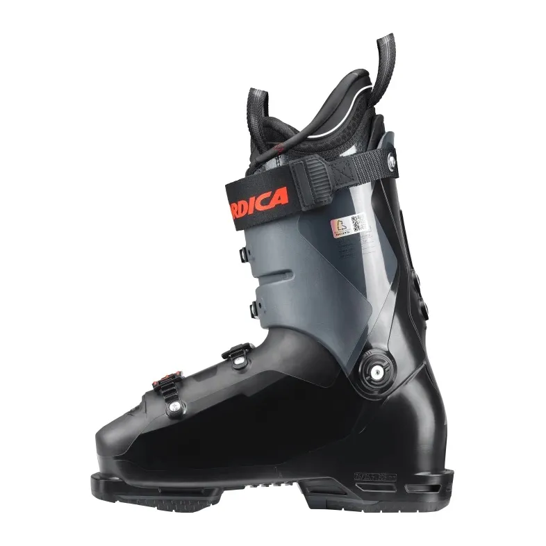 Schwarzer Skischuh der Marke Nordica in Seitenansicht. Zu sehen sind Schnallen, Gurtband mit Markenlogo und Innenschuh.
