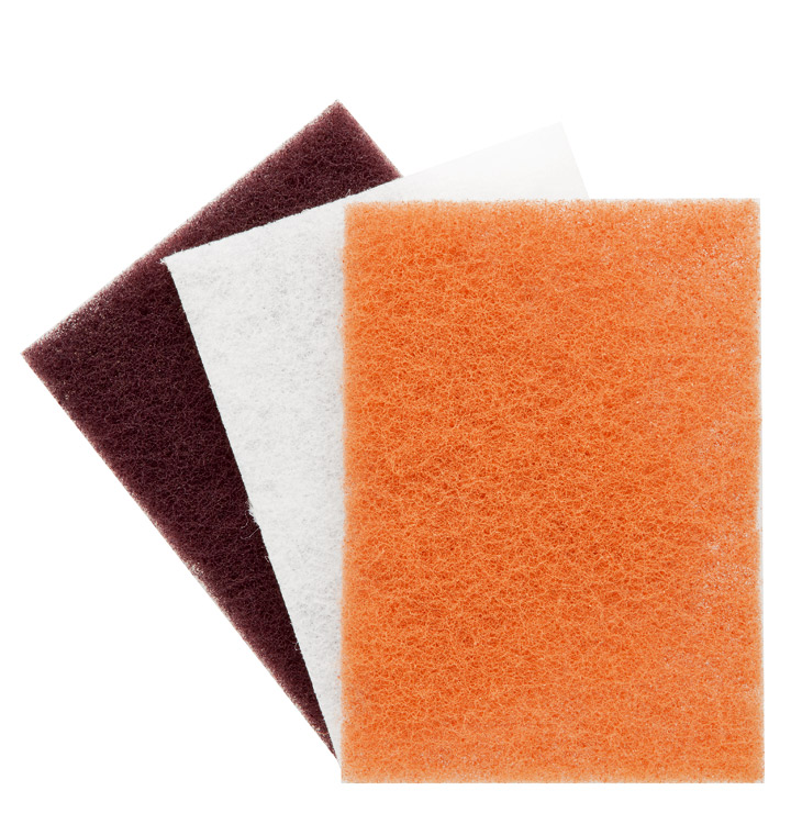 Toko Fibertex Kit: Drei Schleifvlies-Pads in braun, weiß und orange.