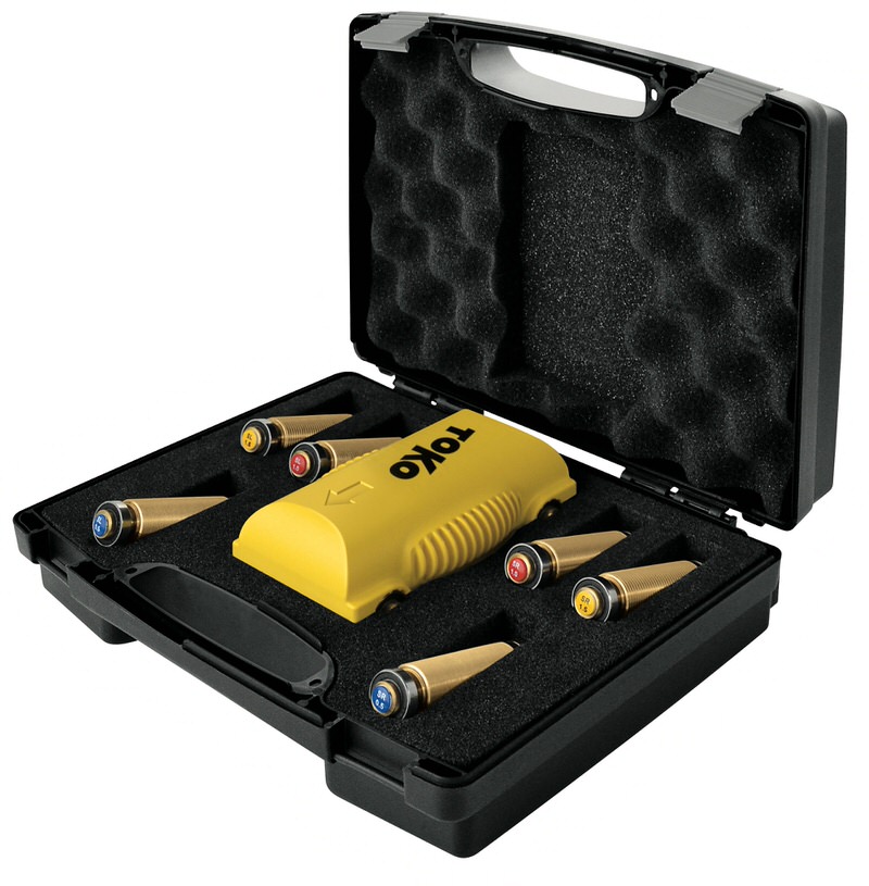 Toko Kit nordique Coffret ouvert avec Toko Structurite Nordic Kit : appareil de structuration jaune et rouleaux de structuration à code couleur pour les skis de fond.