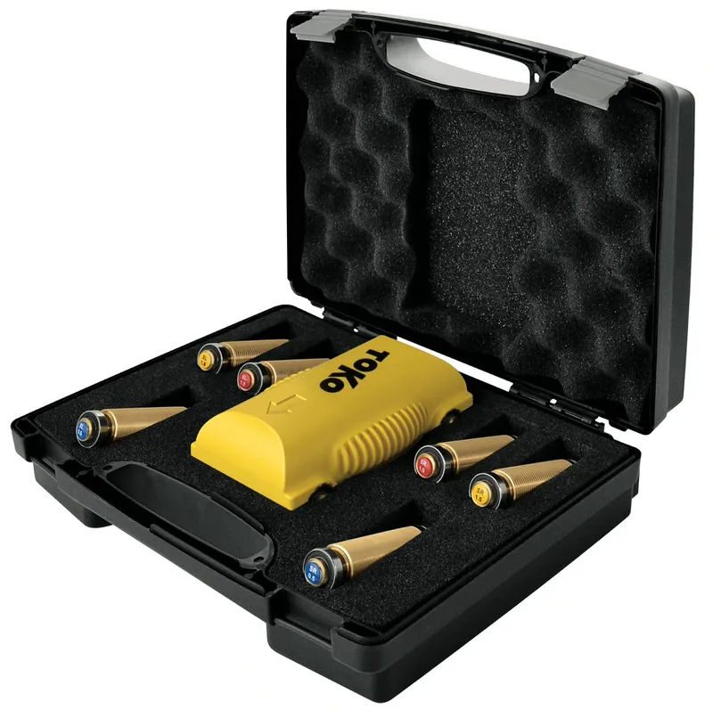 Offener Koffer mit Toko Structurite Nordic Kit: gelbes Strukturiergerät und farbcodierte Strukturwalzen für Langlaufski.