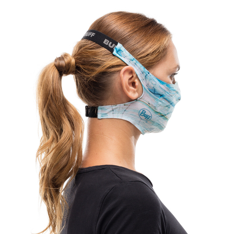 Blaue Buff Filtermaske Frau mit Pferdeschwanz trägt eine blaue Buff Filter Mask Marakrana am Hinterkopf befestigt.