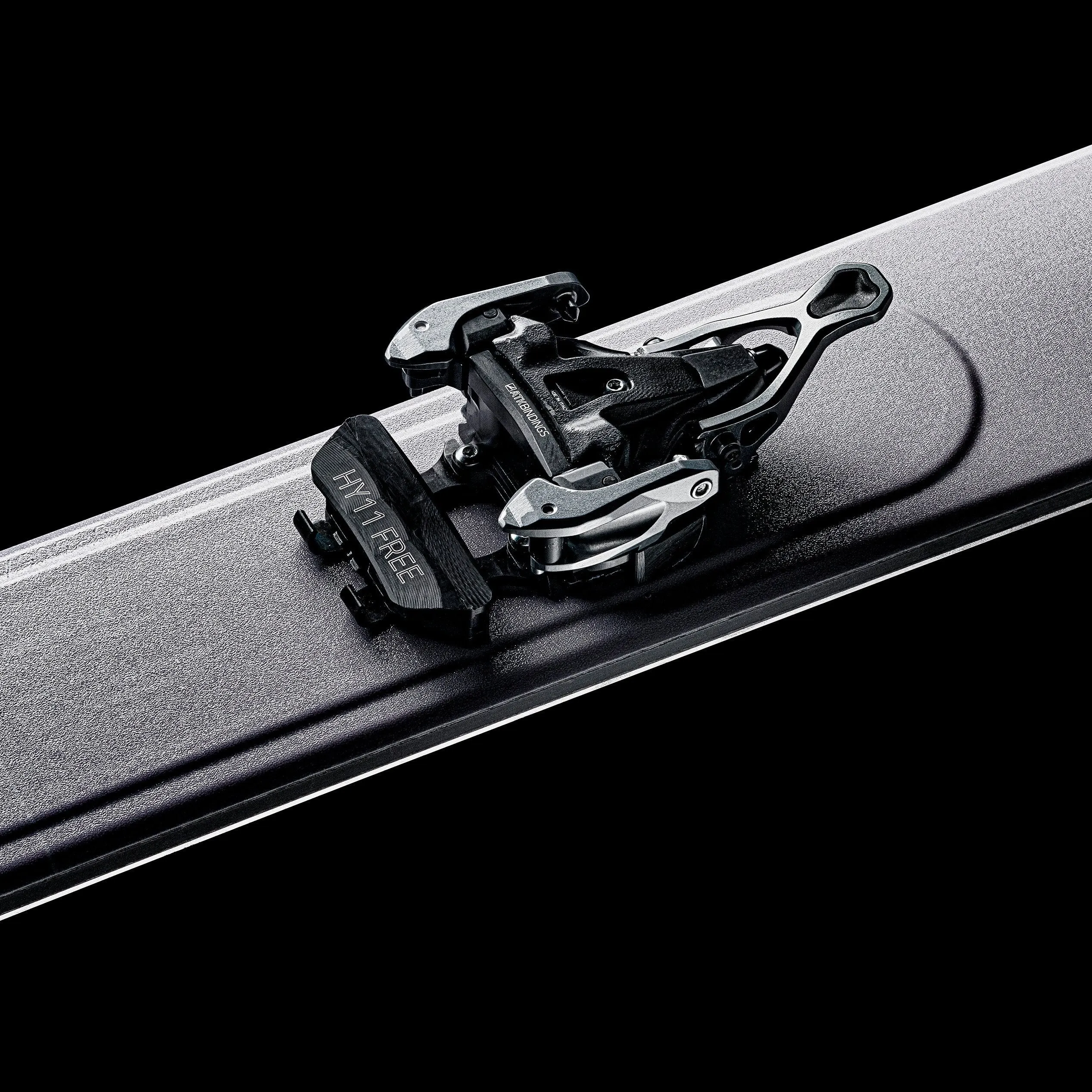 Ski binding close-up on a ski with dark background.