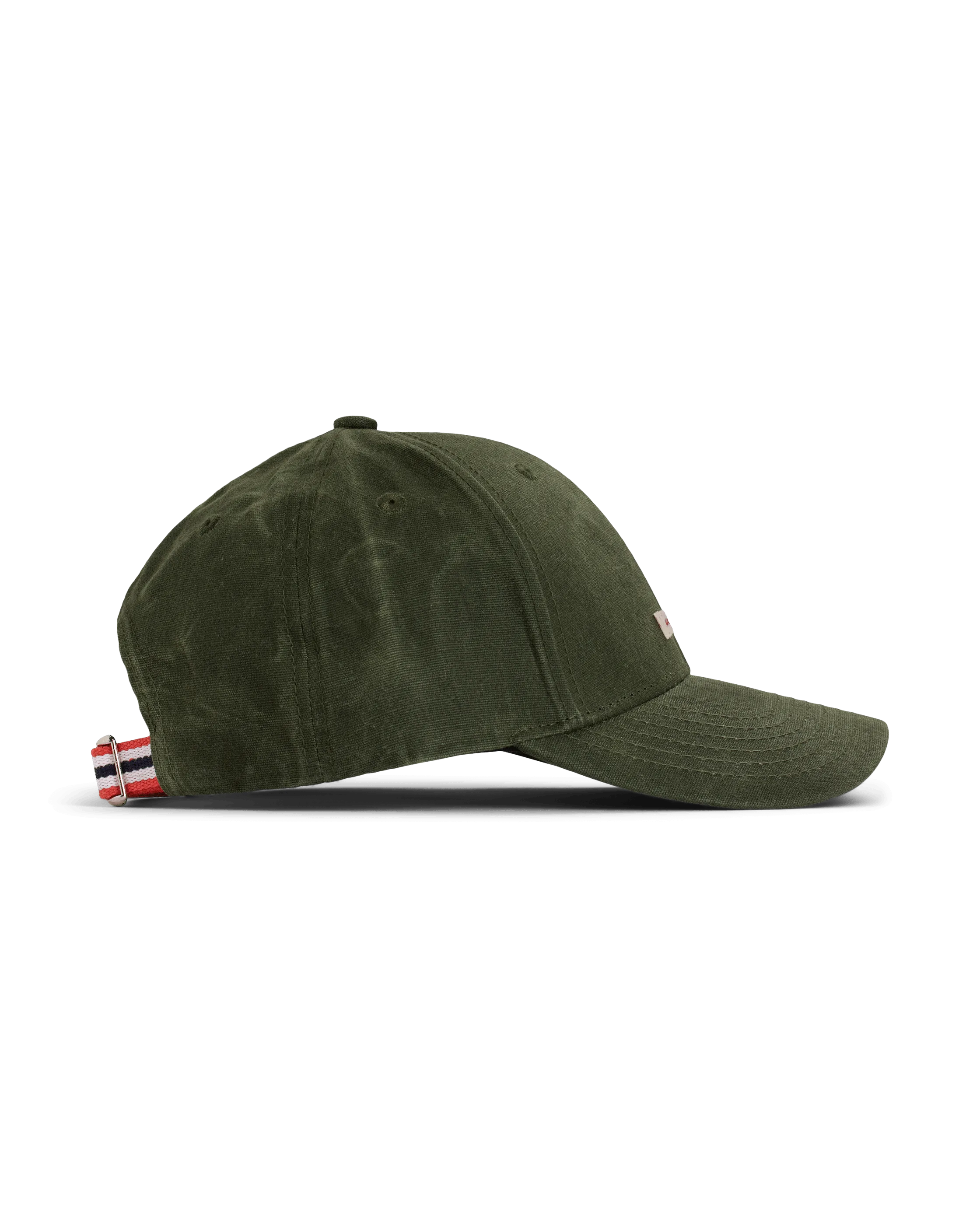An olive green baseball cap lies on a flat surface. It has an adjustable strap with red, white, and blue stripes at the back. The slightly curved brim covers part of a logo. The background is pure white.