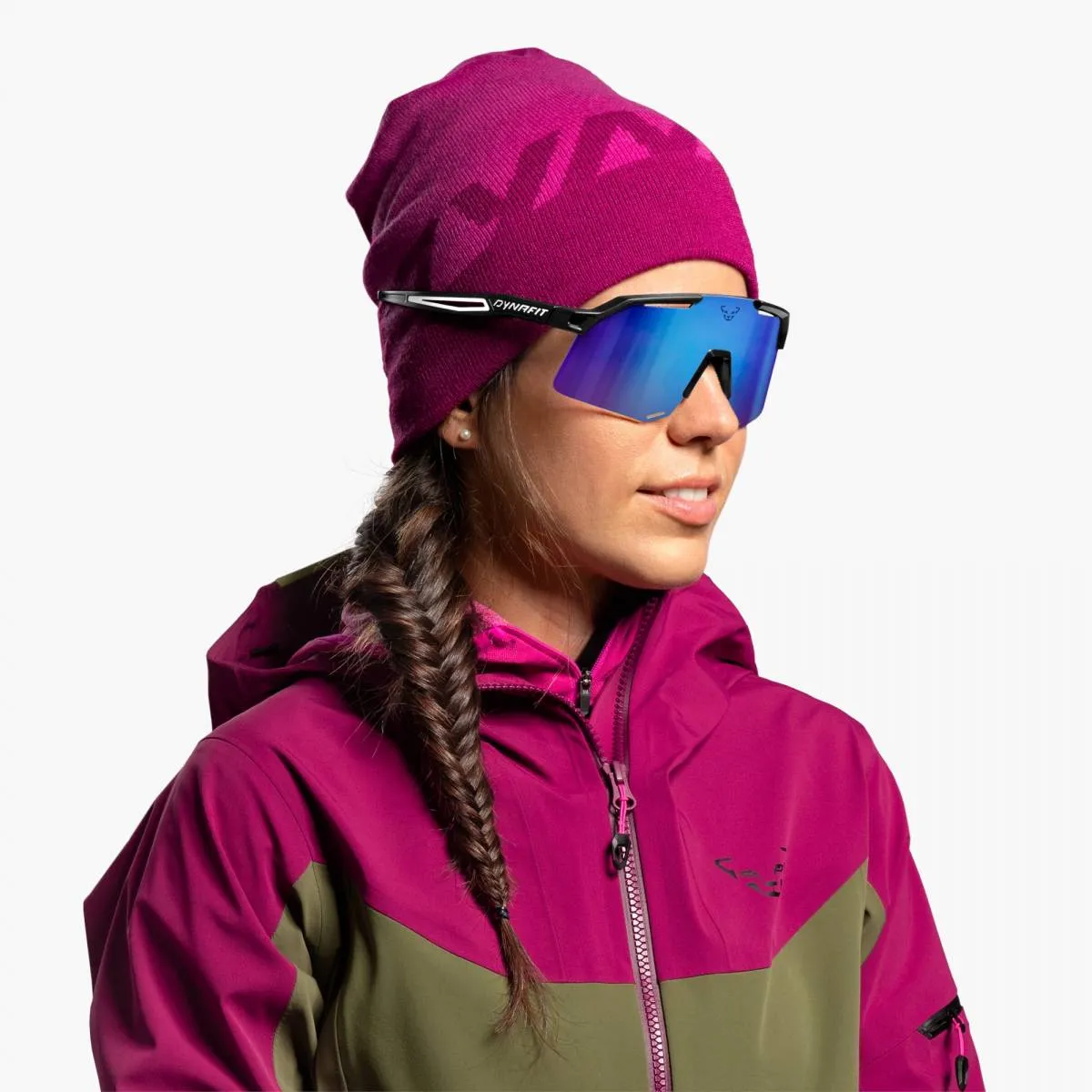 Donna con occhiali da sole Dynafit Ultra Pro con lenti blu e cappuccio rosa.